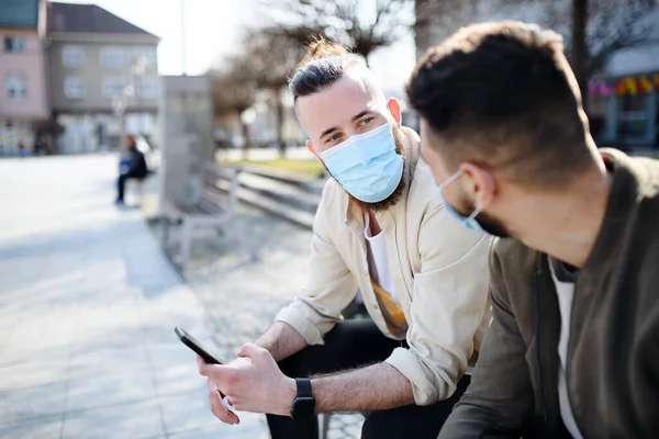 Мужчины друзья на улице в городе говорят, коронавирус и новая нормальная концепция. — стоковое фото