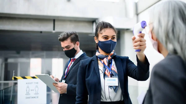 Mulher sênior no terminal do aeroporto, coronavírus, viagens, medição de temperatura e novo normal. — Fotografia de Stock