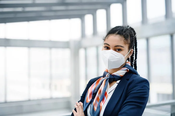 Young air hostess looking at camera in airport lounge, coronavirus, travel and new normal. — Stock Photo, Image