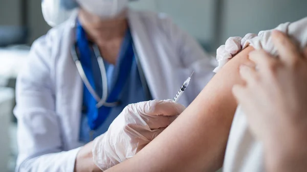 Oigenkännlig kvinna som vaccineras på sjukhus, coronavirus och vaccinationskoncept. — Stockfoto