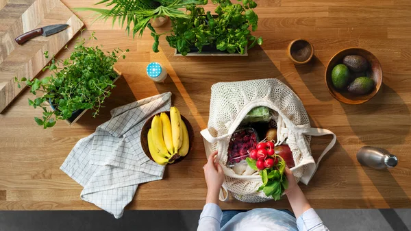 Vista superior de la mujer desembalaje de compras de frutas y verduras, estilo de vida sostenible. —  Fotos de Stock