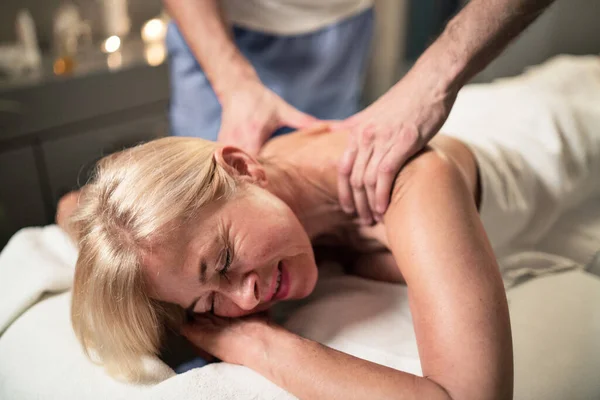 Donna anziana con massaggio alla schiena al centro benessere. — Foto Stock
