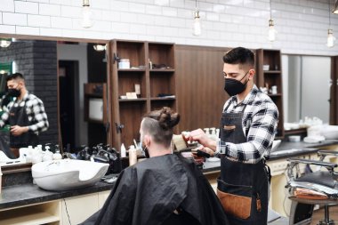 Erkek müşteri berber dükkanını, koronavirüsü ve yeni normal konsepti ziyaret ediyor..