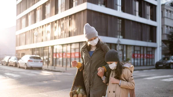 Madre con figlioletta con shopping bags all'aperto su strada, coronavirus concept. — Foto Stock