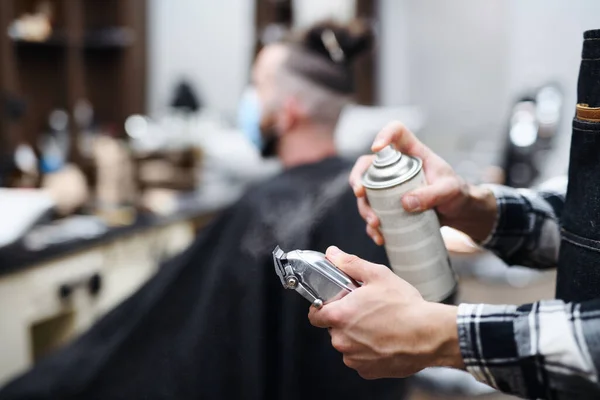 Клиент парикмахерской, неузнаваемый парикмахер, распыляющий стрижку для волос. — стоковое фото