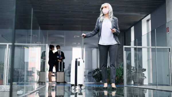 Senior vrouw in de luchthaven lounge, coronavirus, reizen en nieuwe normale. — Stockfoto