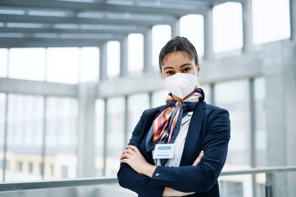 Young air hostess looking at camera in airport lounge, coronavirus, travel and new normal. — Stock Photo, Image