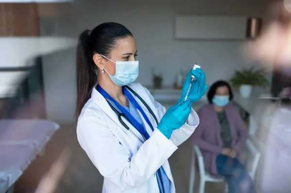 รูปภาพของหมอหญิงที่มีเข็มฉีดยายืนอยู่ในโรงพยาบาล แนวคิดของไวรัสโคโรนา . — ภาพถ่ายสต็อก