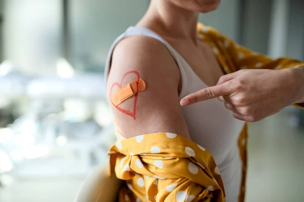 在医院接种疫苗后手臂上涂石膏的无法辨认的妇女，推广概念. — 图库照片