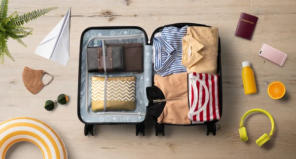 Плоский вид упакованного чемодана и путешествия, летний отдых, коронавирус и новая концепция. — стоковое фото
