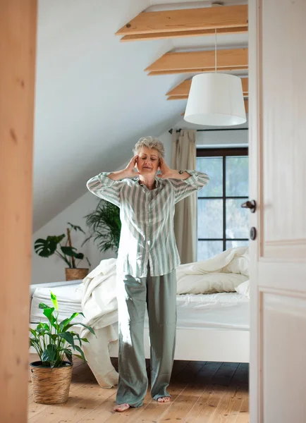 Старшая женщина в постели дома встает по утрам, растягивается. — стоковое фото