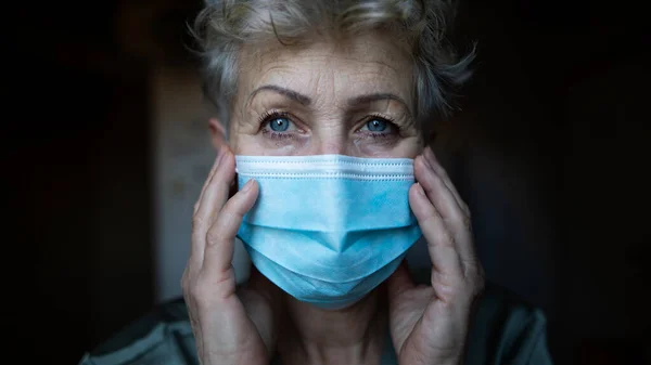 Przygnębiona starsza kobieta z maską twarzy w domu, koronawirusem i koncepcją zdrowia psychicznego. — Zdjęcie stockowe