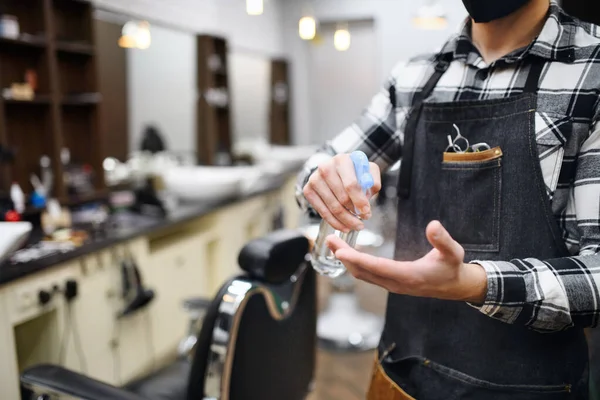 Haidresser uomo irriconoscibile disinfettante mani in negozio di barbiere, coronavirus e nuovo concetto normale. — Foto Stock