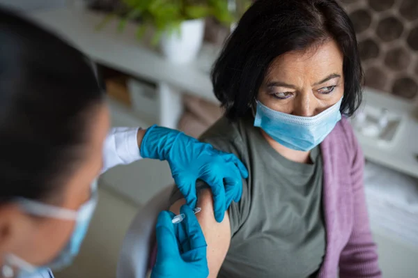 Ovanifrån av äldre kvinna som vaccineras på sjukhus, coronavirus och vaccinering koncept. — Stockfoto