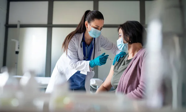 Oudere vrouw wordt gevaccineerd in het ziekenhuis, coronavirus en vaccinatie concept. — Stockfoto