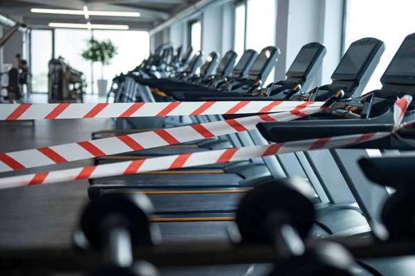 Marking tape on treadmill machines in gym, safe distance and coronavirus concept. — Stock Photo, Image