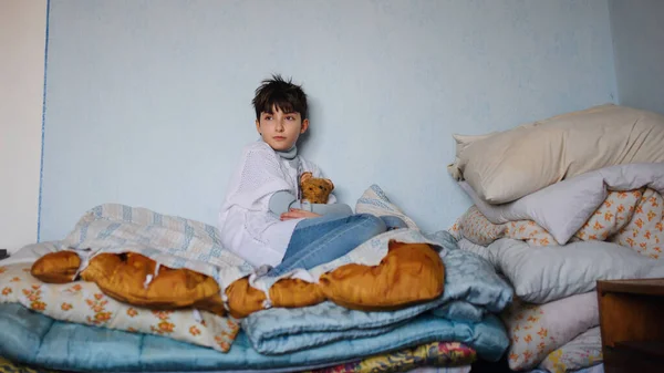 Poor sad small girl on bed indoors at home, poverty concept. — Stock Photo, Image