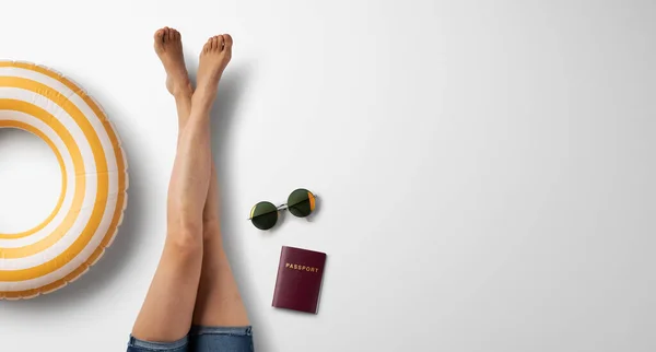 Flat lay vista superiore delle gambe della donna con elementi essenziali di viaggio, concetto di vacanza estiva. — Foto Stock