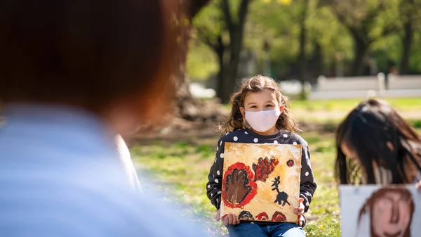 Маленькі діти з учителем на відкритому повітрі в міському парку, вивчення групової освіти та концепції коронавірусу . — стокове фото
