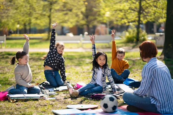 城市公园里有幼儿的教师，学习小组教育的概念. — 图库照片