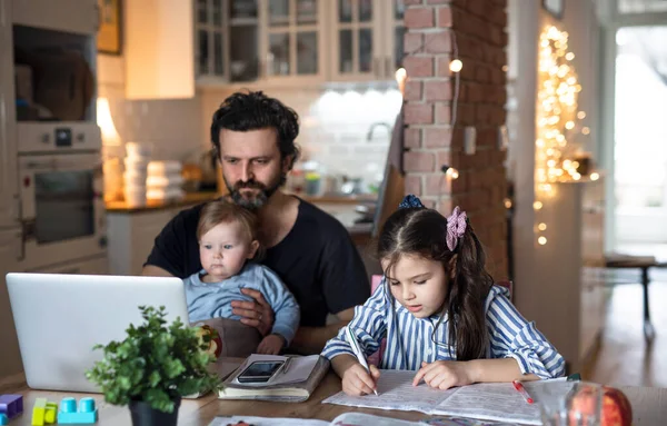 Vader met kleine dochters in keuken, afstandsonderwijs, thuiskantoor en schoolconcept. — Stockfoto