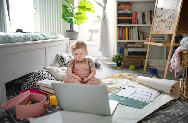 집 바닥에 누워 있는 작은 아기가 노트북으로 이야기를 보고 있습니다. — 스톡 사진
