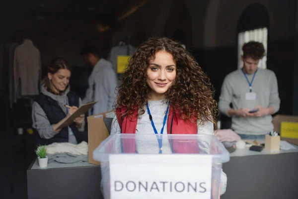 Vrouw vrijwilliger werken in gemeenschap liefdadigheid donatie centrum, op zoek naar camera. — Stockfoto