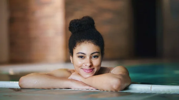 Портрет молодой женщины в закрытом бассейне, смотрящей в камеру. — стоковое фото
