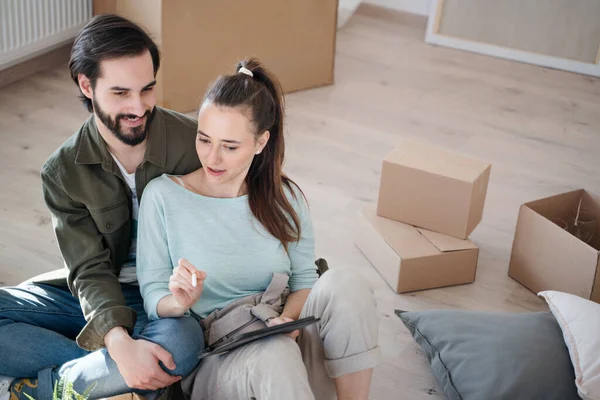 Jeune couple avec tablette de planification lors du déménagement dans un nouvel appartement, nouvelle maison et concept de relocalisation. — Photo