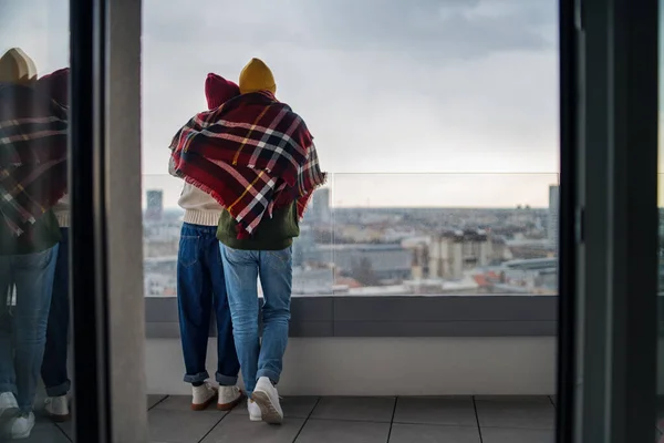 Vista trasera de los propietarios de parejas jóvenes en el balcón en el nuevo piso, mudanza, nuevo hogar y concepto de reubicación. — Foto de Stock
