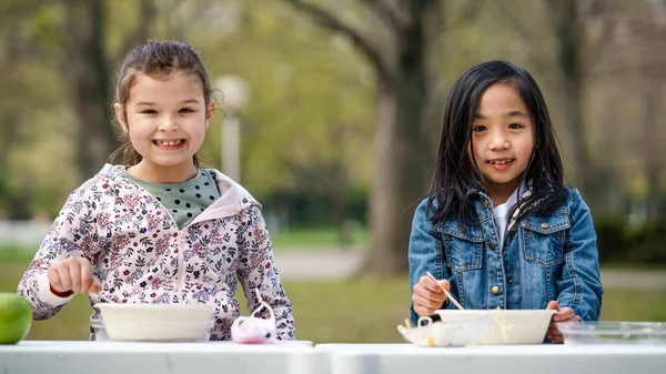 Niños pequeños almorzando al aire libre en el parque de la ciudad, aprendiendo concepto de educación en grupo. — Foto de Stock