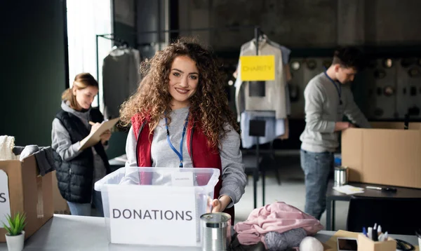 Vrouw vrijwilliger werken in gemeenschap liefdadigheid donatie centrum, op zoek naar camera. — Stockfoto