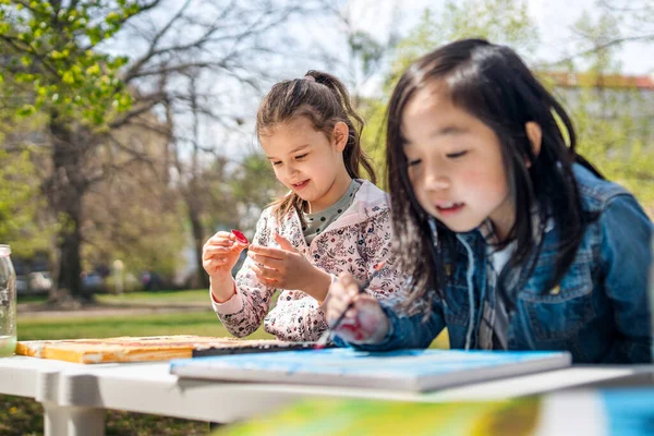 Маленькие дети рисуют картины на открытом воздухе в городском парке, концепция группового обучения. — стоковое фото