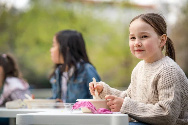 Маленькие дети обедают на открытом воздухе в городском парке, концепция группового образования. — стоковое фото