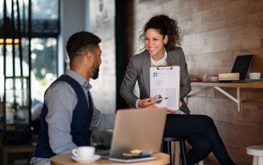 Kafe, serbest çalışma ve sunum kavramında çalışan dizüstü bilgisayarlı iş adamları.