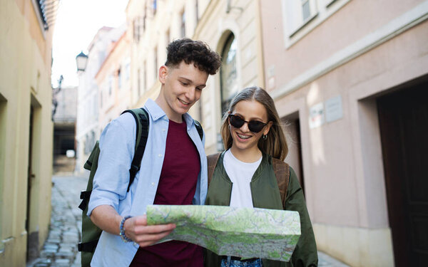 Молодая пара путешественников с картой в городе на отдыхе, осмотр достопримечательностей.