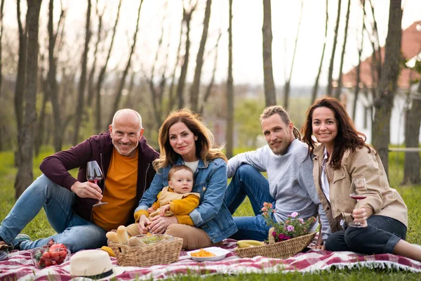 Szczęśliwa wielopokoleniowa rodzina na świeżym powietrzu o piknik w przyrodzie. — Zdjęcie stockowe