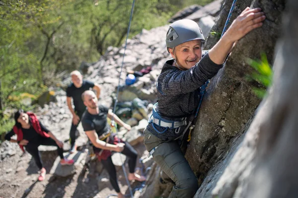 Groupe d'aînés avec instructeur escalade des rochers en plein air dans la nature, mode de vie actif. — Photo