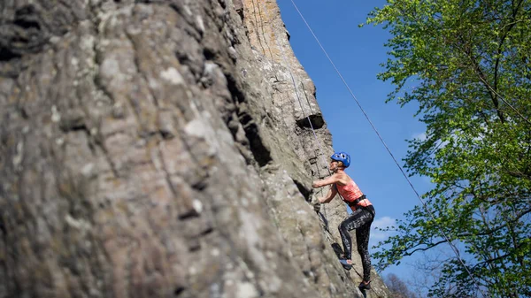 Mid vuxen kvinna klättra stenar utomhus i naturen, aktiv livsstil. — Stockfoto