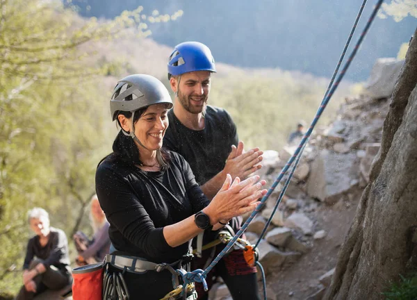 Grupp av seniorer med instruktör använder krita innan du klättrar stenar utomhus i naturen, aktiv livsstil. — Stockfoto