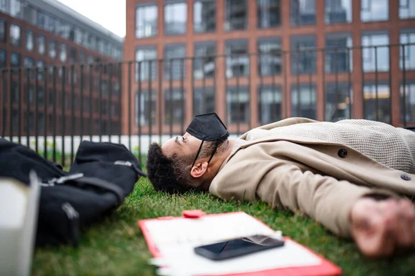 Zdenerwowany człowiek z laptopem leżącym na zewnątrz w parku w mieście, koronawirusem i koncepcją pracy. — Zdjęcie stockowe