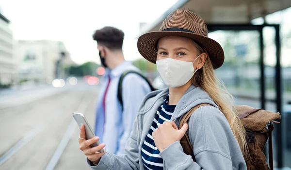 Νεαρή γυναίκα τουρίστας ταξιδιώτης σε διακοπές περιμένει στη στάση του λεωφορείου στην πόλη, concept coronavirus. — Φωτογραφία Αρχείου