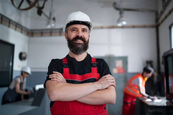 Retrato de trabalhador com capacete dentro de casa na fábrica olhando para a câmera. — Fotografia de Stock