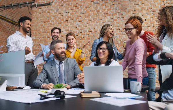 Grupo de emprendedores entusiasmados trabajando en proyectos en interiores en la oficina, celebrando un contrato exitoso. — Foto de Stock