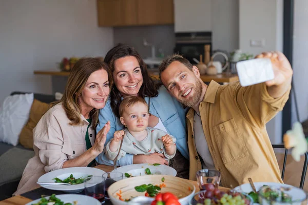 Szczęśliwa wielopokoleniowa rodzina w domu jedząc zdrowy lunch, robiąc selfie. — Zdjęcie stockowe