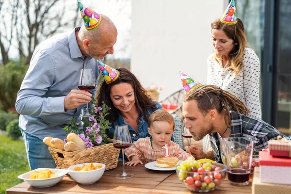 Happy multigeneration family outdoors in garden at home, birthday celebration party. — Stock Photo, Image