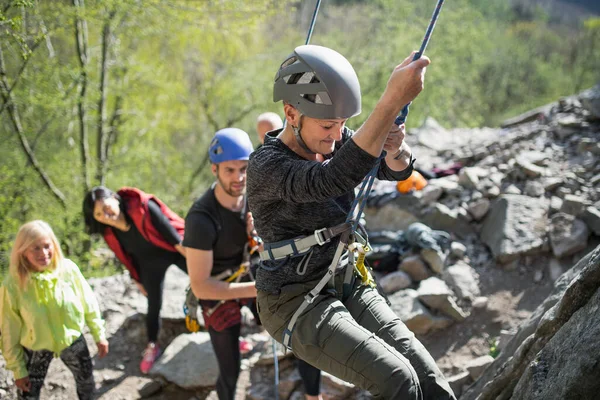 Groupe d'aînés avec instructeur escalade des rochers en plein air dans la nature, mode de vie actif. — Photo