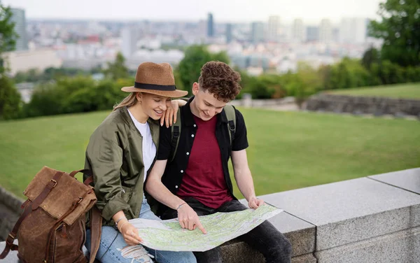Jóvenes viajeros en pareja con mapa en la ciudad de vacaciones, descanso y planificación. — Foto de Stock