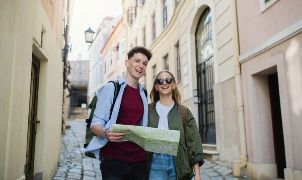 Young couple travelers with map in city on holiday, sightseeing. — Stock Photo, Image