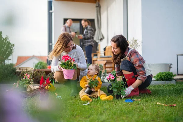 Szczęśliwa wielopokoleniowa rodzina na zewnątrz sadzenie kwiatów w ogrodzie w domu, koncepcja ogrodnictwa. — Zdjęcie stockowe